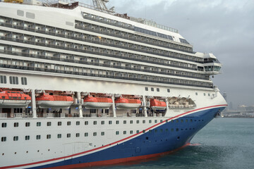Obraz premium Modern cruiseship or cruise ship liner Freedom arrival into port of Barcelona Espana, Spain gateway in summer during Mediterranean cruising