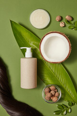 Natural hair care bottle with coconut and botanical leaves on green background. Fresh organic concept with blank label and copy space for cosmetic design © Tuan  Nguyen 