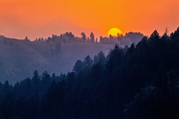 Sunset in a hilly landscape with a golden light on the sky