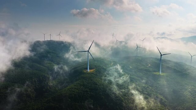 Modern wind turbines on a misty mountain ridge generating green energy in the morning