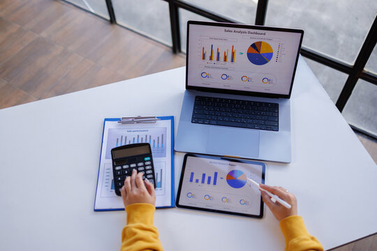 Business using calculator and laptop for do math finance on wooden desk in office and business working background, tax, accounting, statistics and analytical research concept
