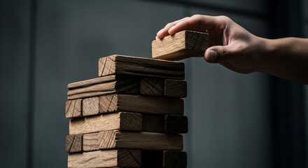 Hand Placing Wooden Block on Stack.