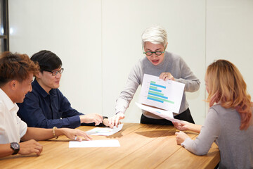 Obraz premium senior businesswoman meeting and showing chart document in the office