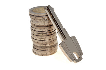 Concept de d&eacute;penses li&eacute;es au logement avec une pile de pi&egrave;ces en euros et une cl&eacute; de maison en gros plan isol&eacute;es sur fond blanc