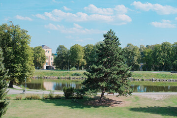 Fototapeta premium Peaceful Summer Landscape of Ostrov Park in Nymburk, Czech Republic with Lush Greenery and Elbe River