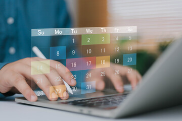 Digital calendar planning concept with virtual schedule interface over laptop keyboard. Online...