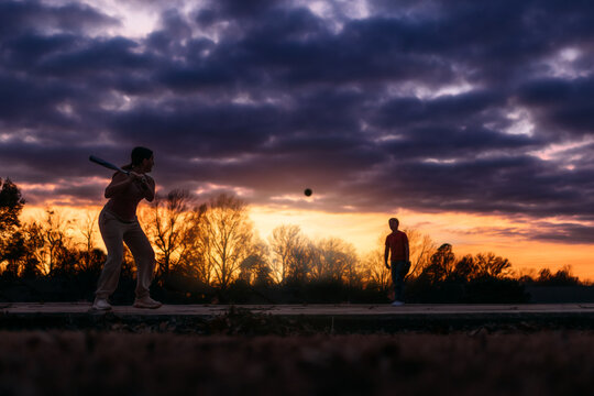 Two Children Playing Baseball at Sunset