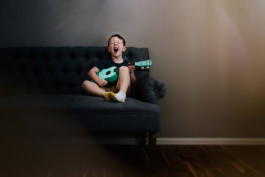 Boy Singing Loudly with Toy Guitar