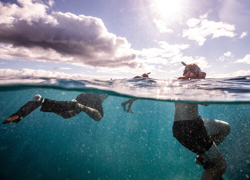 family snorkeling underwater and clouds
