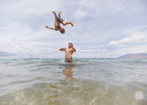boy doing a flip after brothers throws him in the air