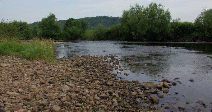 wide shot looking up the river Lune with a rocky shoreline. at Brookhouse