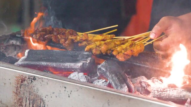 Street Vendor Grilling Chicken Satay Over Hot Charcoal Flames in Singapore