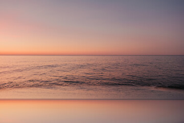 Calm sea at pastel sunset with soft horizon