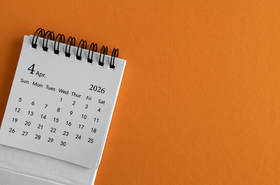 Desk calendar for April 2026 on an orange background.