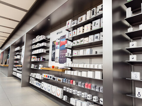 Apple devices on display in a sleek Manchester retail store with shelves and gadgets
