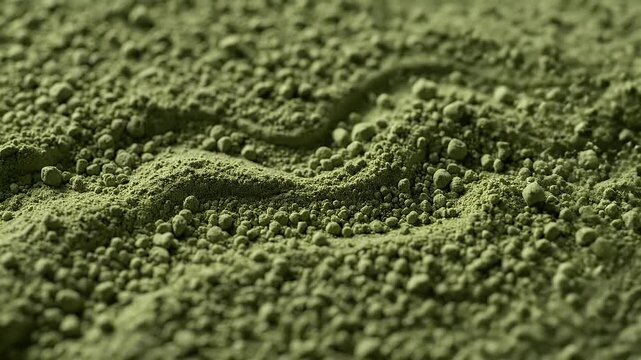 Close-up of green matcha powder texture with uneven surface.