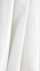 Fototapeta premium White fabric drapes with soft folds and smooth texture in bright light
