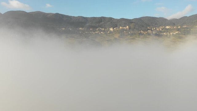 Panoramic drone flight through clouds reveals spectacular rice terraces and traditional villages in mountains of Yuanyang region in China
