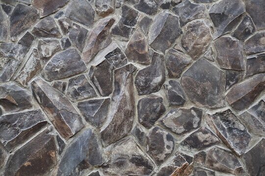 Natural stone wall texture with rustic pattern, durable surface, elegant architectural exterior design.