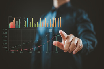 Business person pointing at virtual financial growth graph with colorful bar charts and line trend from 2021 to 2026