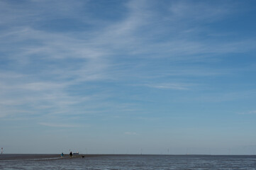 Low tide on the North Sea coast, with mudflat hikers on the horizon