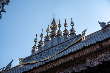 Separate fragments of a decorated Buddhist temple in Thailand on a sunny day