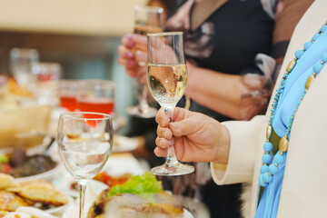 Obraz premium People holding glasses at a gathering with food on a table