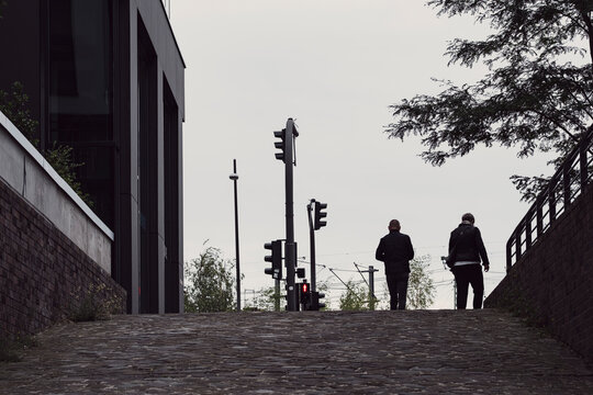 Urban underpass stairs with streetlights in Hamburg Germany show evening silhouette near architecture lines and strong perspective for moody commute scene