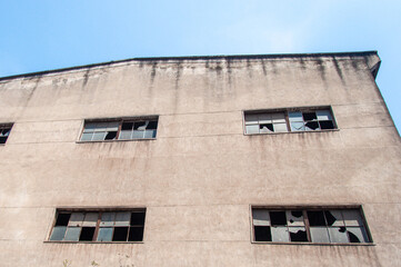 Fototapeta premium Low Angle View of Concrete Facade with Broken Windows