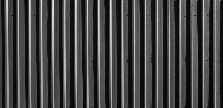 Black Corrugated metal texture surface or galvanized steel. ribbed painted metal fence panelling background Black corrugated metal texture, dark abstract backdrop