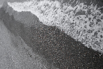 Obraz premium Black Sea. water wave on pebble beach shore. Batumi, Georgia. top view on blue aqua surface. top aerial view. Sea blue water wave on pebble beach shore. diagonal.