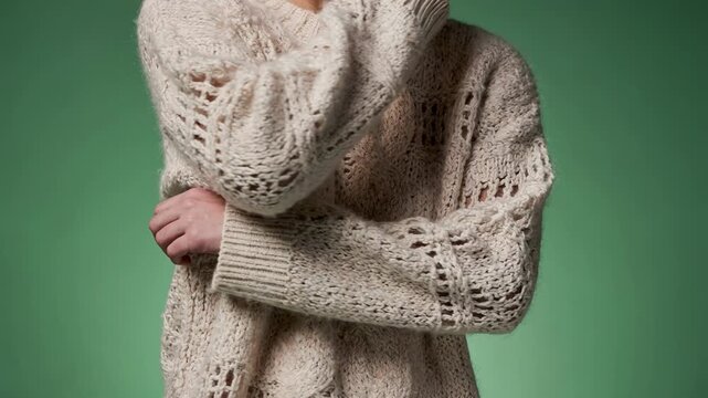 Medium shot of lowimpact textured knitwear emphasizing innovative compostable fibers and intricate patterns in a green studio setting.