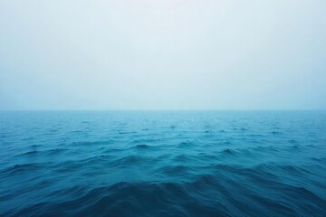 Obraz premium Vast, endless ocean meeting the hazy horizon, a tranquil scene of blue and grey under a calm sky Perfect for travel, nature, and serenity themes , wide, beautiful, tranquil