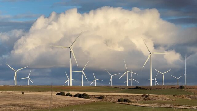 Wind turbines in rural landscape with cloudy sky