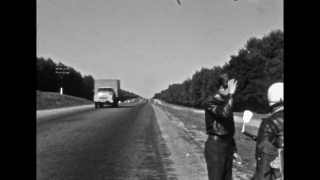 Biker friends stopped for smoke cigarette break, relax along roadside in motorcycle journey. Riders rest, enjoy pause near parked motorcycles in road trip. Old film. Archival retro. Vintage archive