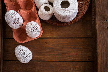 vertical Easter background, crochet Easter eggs, handmade decoration, white lace eggs, rustic wooden table, egg carton, spring holiday, farmhouse decor, country style, slow living, cozy atmosphere, ho