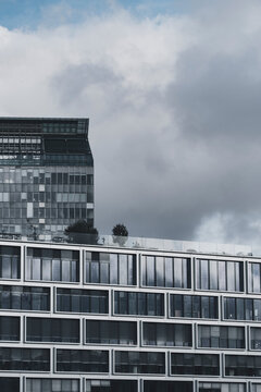 Clouds above a minimal skyline show modern corporate building facade and office windows where architecture feels calm and understated