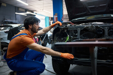 A mechanic is expertly repairing a car engine in a professional garage workshop setting