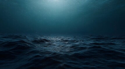 Obraz premium Serene underwater view of the ocean surface with sunlight filtering through dark blue water and gentle waves