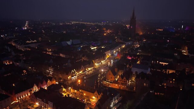 Night footage of Bruges, Belgium, featuring illuminated medieval streets and canals decorated for Christmas. Festive lights reflect on the water in a magical winter atmosphere.