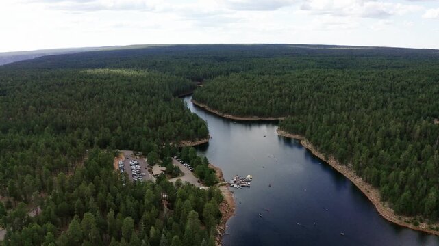 Drone shot pulling away from the Woods Canon Lake campground in Arizona's dense forest.