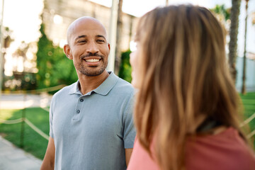 Obraz premium Couple enjoys a sunny day walking together in a charming urban area during late afternoon or tourists visiting a destination