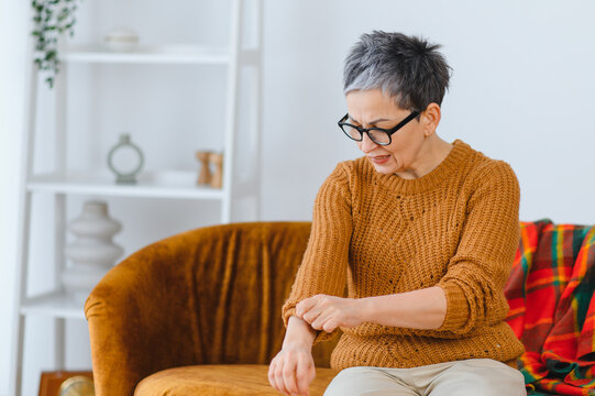 Senior woman scratching arm having skin allergy
