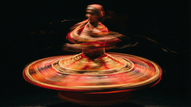 Motion blur of a traditional dancer spinning in a colorful skirt. Whirling dervish or Tanoura performance on black background. International Day of Culture concept