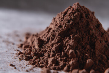 A fine, rich mound of cocoa powder captures attention with its deep brown color and texture, invoking thoughts of delicious chocolate creations and culinary possibilities.