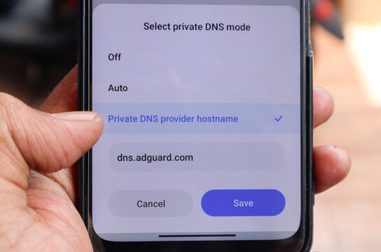 Phone showing custom private DNS interface on mobile phone. The DNS set to adguard DNS to block ads and prevent any malicious activity on internet. Depok, Indonesia 17 Oct 2025.