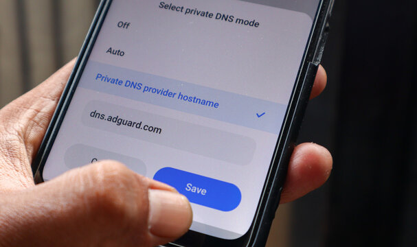 Phone showing custom private DNS interface on mobile phone. The DNS set to adguard DNS to block ads and prevent any malicious activity on internet. Depok, Indonesia 17 Oct 2025.