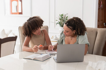 Woman teaching young girl studying knowledge and learning
