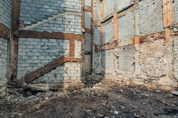 Abandoned building structure with ruined interior brick walls and exposed wooden beams