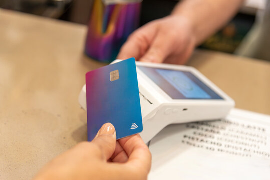 Customer making contactless payment with credit card at retail store